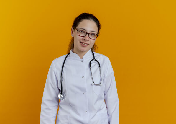 人面带微笑的年轻女医生穿着医用长袍和听诊器 戴着隔离眼镜女士橙色医生