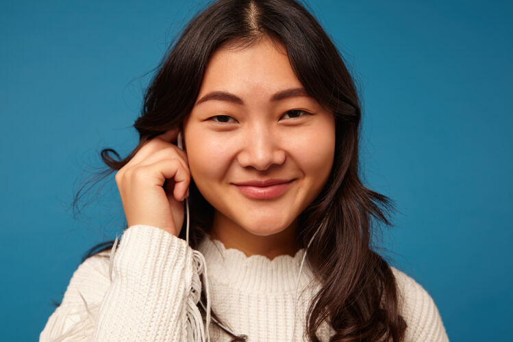 耳机积极的年轻迷人的黑发女子高兴地看着镜头情感音乐亚洲人