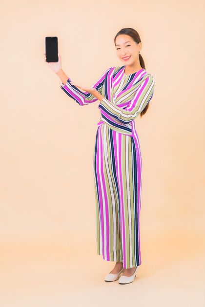 互联网肖像美丽的亚洲年轻女子用智能手机上色女性女士手机