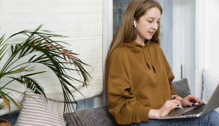 女人在笔记本电脑上工作的女人的侧视图工作场所笔记本电脑工作场所