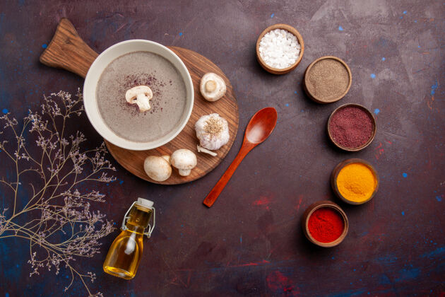 新鲜在黑暗的桌子上俯瞰美味的蘑菇汤和新鲜的蘑菇和调味品蘑菇储蓄过滤器