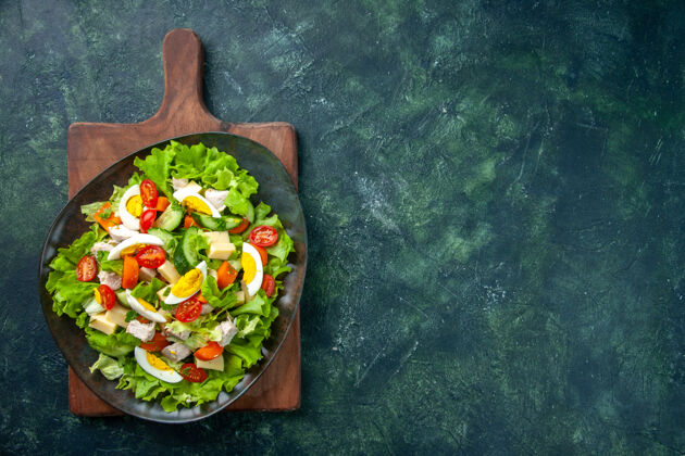 蔬菜美味沙拉的俯视图 在黑绿色混合色背景的木质砧板上 右侧有许多新鲜的配料沙拉健康顶部