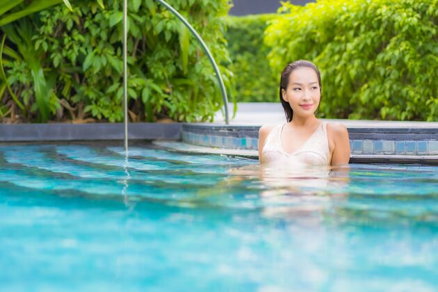 水美丽的年轻女子在游泳池放松的画像美丽酒店游泳池