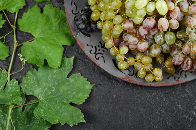 有机一盘深色背景上有叶子的混合葡萄高质量的照片陶瓷季节水果