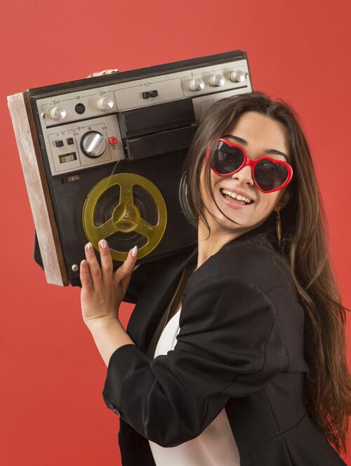 太阳镜戴着太阳镜和收音机的女人音乐笑脸收音机