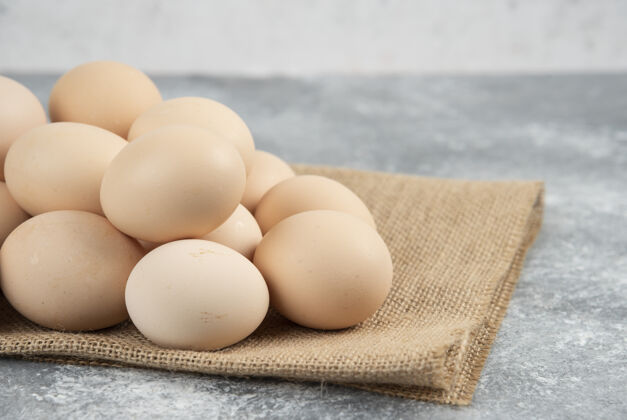 禽类一堆有机生鸡蛋和桌布放在大理石表面鸡堆桌布