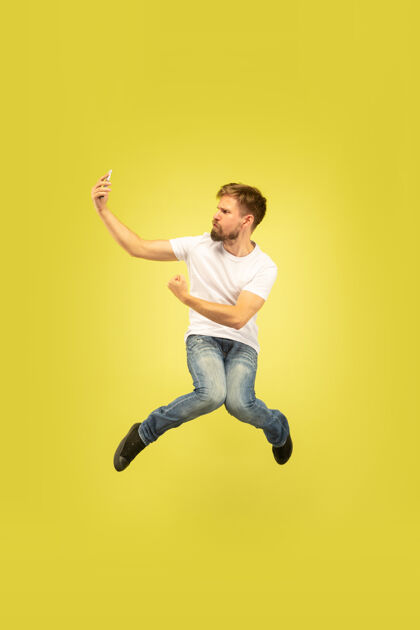 灵感黄色背景上孤立的快乐跳跃人的全长肖像穿着休闲服的白人男模自由选择 灵感 人类情感的概念在奔跑中自拍帅气男孩成功
