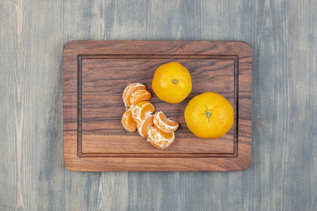 克莱门汀把整个橘子切成片放在木砧板上美味柑橘收获