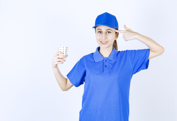 工人穿着蓝色制服的女孩端着一杯饮料 思考着或者有了新的想法女性促销计划