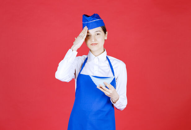 烹饪穿着蓝色围裙的厨师手里拿着一碗陶瓷菜 看上去很累员工女性厨房