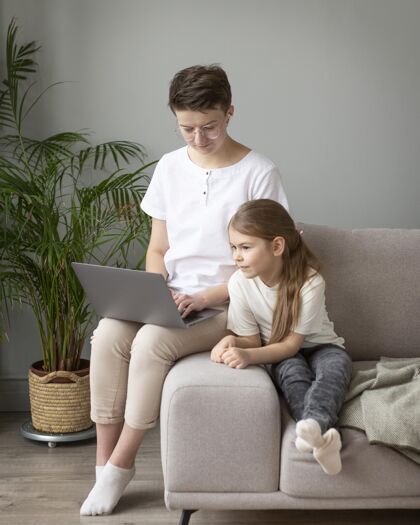 远程孩子和家长在看笔记本电脑女孩生活方式全镜头