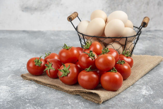 菜肴一篮子新鲜的生鸡蛋和成熟的西红柿放在大理石上鸡肉番茄自然