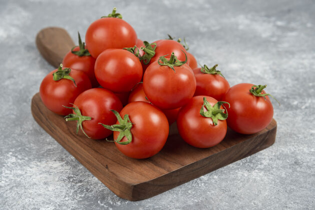 烹饪木头砧板上放着一堆鲜红的西红柿成熟的营养叶子