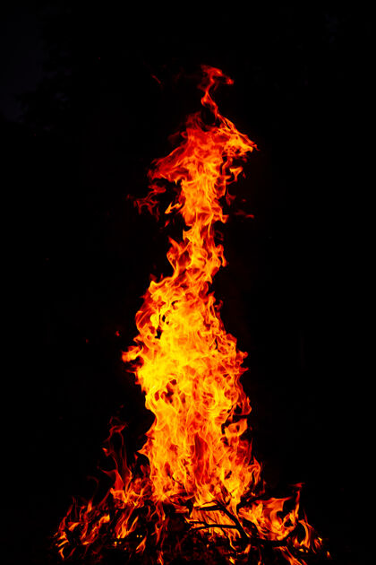 危险一个美丽的垂直拍摄一个大型火灾在夜间壁炉温暖木头