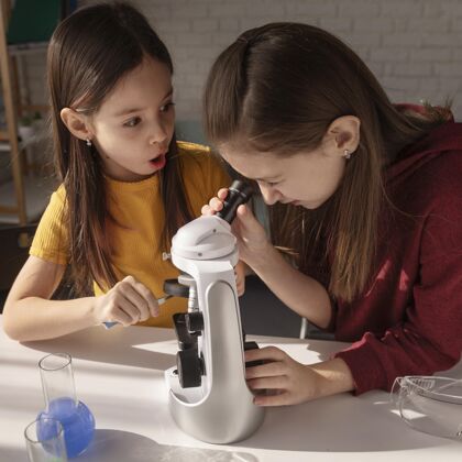 学生中镜头女孩学习显微镜孩子显微镜学习