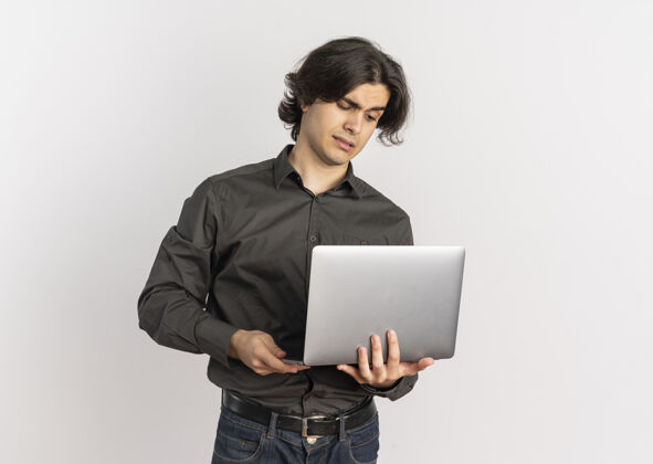 英俊年轻帅气的白种人拿着一台笔记本电脑 看着它 白色的背景上有一个空白笔记本电脑年轻拿着