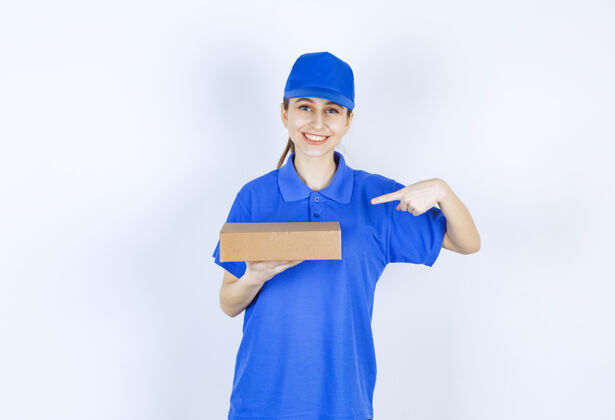 聪明穿着蓝色制服的女孩手里拿着一个纸板外卖盒服装快递员工