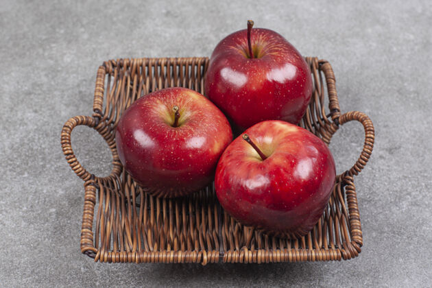 成熟的三个红苹果放在木篮里有机苹果水果