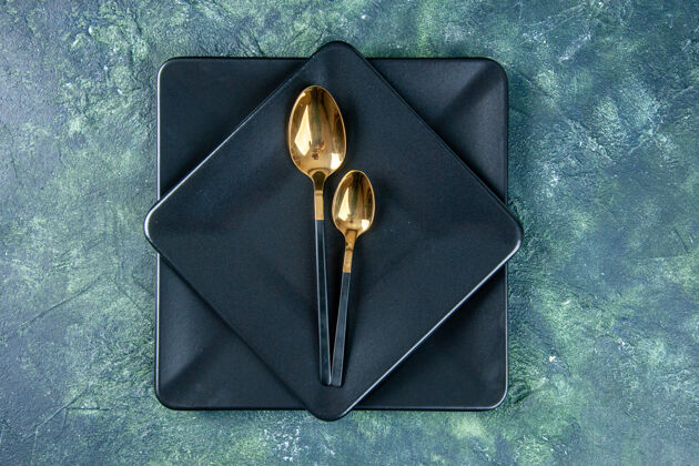 咖啡馆顶视图黑色盘子和金色的勺子在黑暗的表面颜色食品餐厅晚餐厨房咖啡厅钱包勺子晚餐