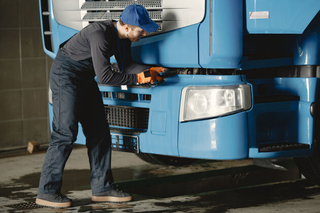 男性一个年轻工人检查车轮卡车故障维修工作汽车工作制服