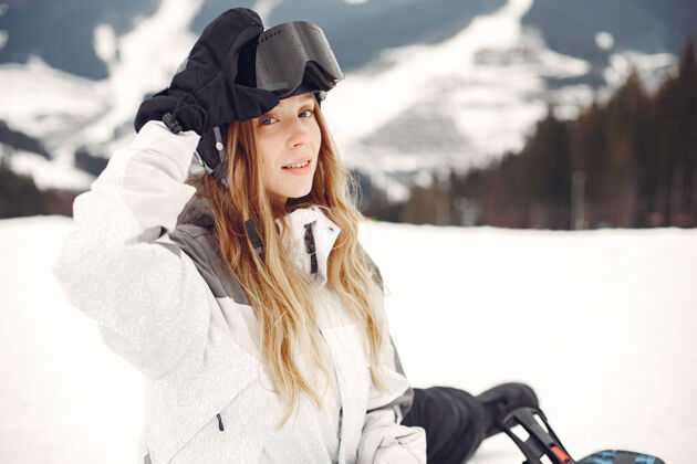 人穿着滑雪板套装的女人在山上手拿滑雪板的运动员在地平线上关于运动的概念黑设备度假村