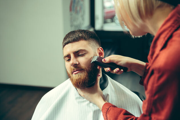 小胡子客户在理发店剃须女理发师在沙龙性别平等女性在男性职业性别顾客脸