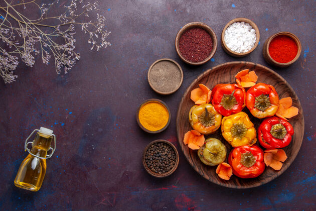 可食用水果顶视图煮熟的甜椒与不同的调味料对灰色办公桌餐蔬菜肉多尔玛食品顶部景观膳食