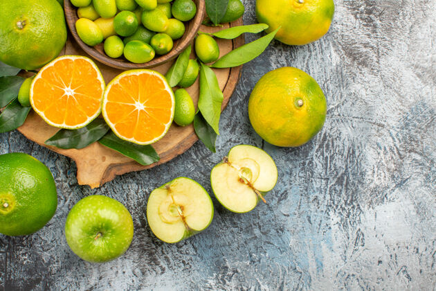 柠檬顶部特写查看柑橘类水果柑桔苹果周围的砧板与柑橘类水果国语健康多汁
