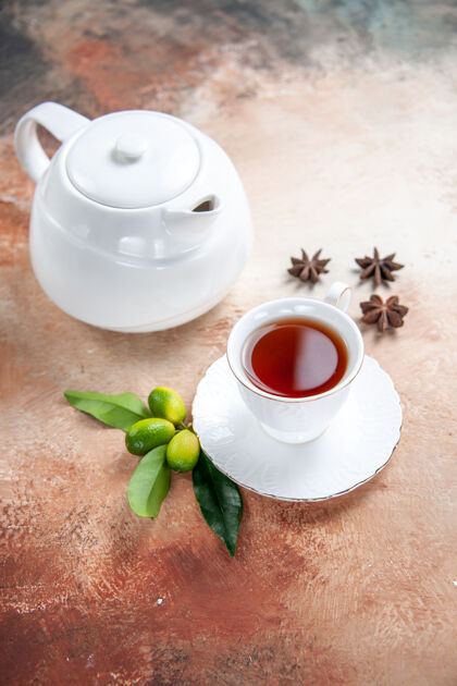 八角侧面特写一杯茶白色茶壶一杯茶柑橘水果八角茴香热壁板茶