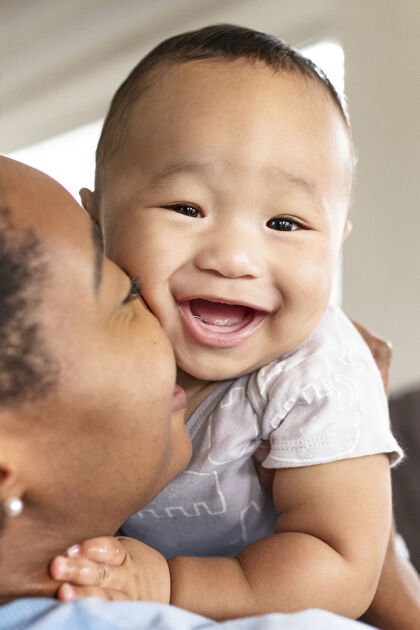 爱非洲裔美国母亲亲吻她的儿子男孩微笑优质时间