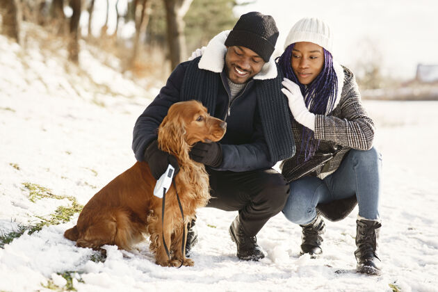 约会人们在外面散步冬天非洲夫妇带着狗人激情一起