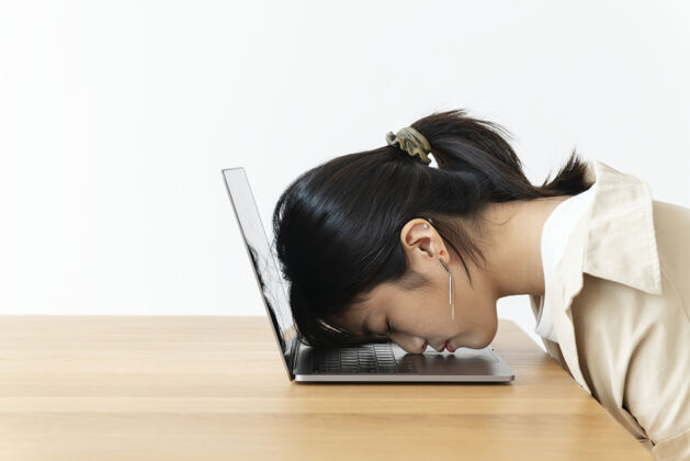 压力紧张的亚洲女孩把头靠在笔记本电脑上女人女人筋疲力尽