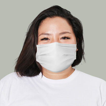 亚洲人戴面具的女人脸特写covid-19绿色背景基本疾病空气污染