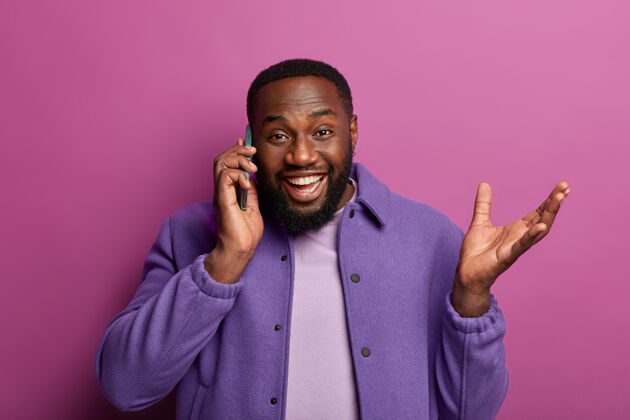 男人热情快乐的男人通过手机交谈 接到朋友或同事的电话 讨论好消息 举手 动情地说些什么非裔手机说话