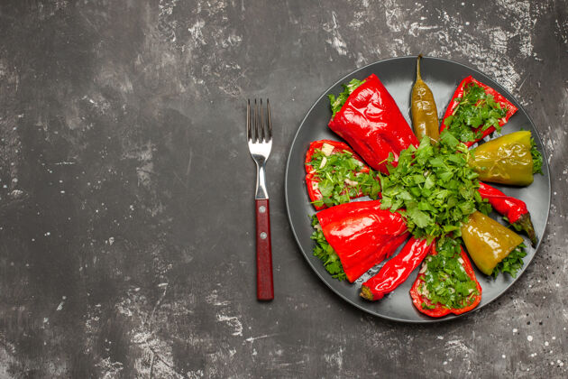 一餐辣椒盘顶视图五颜六色的辣椒和草药放在叉子和刀子之间的盘子里刀西红柿蔬菜