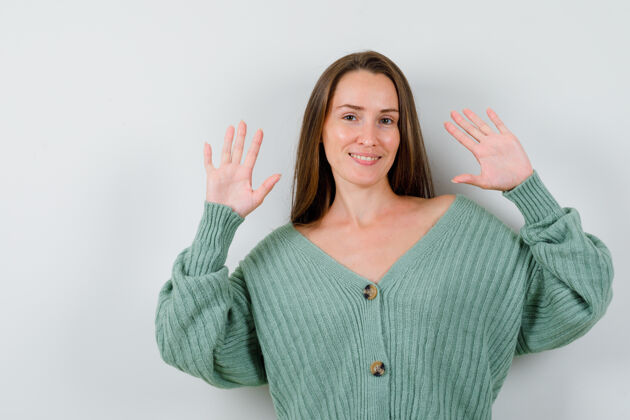 健康穿着羊毛开衫的年轻女士展示投降手势的肖像 看起来很自信自然手掌前面