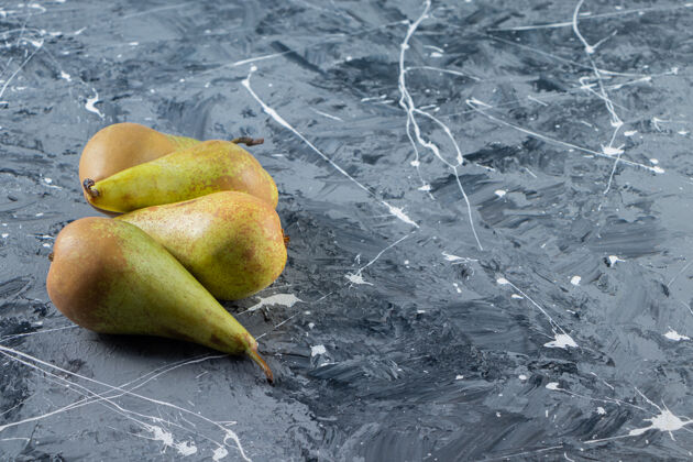 成熟四个新鲜的梨放在大理石桌上健康素食食物