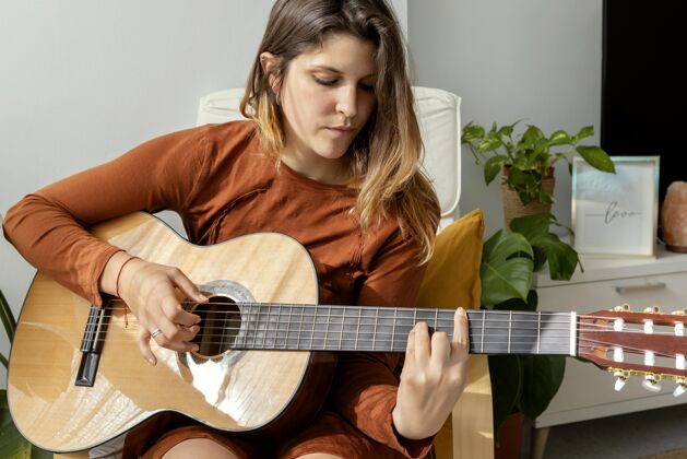 女人在家弹吉他的女人室内活动夸伦特