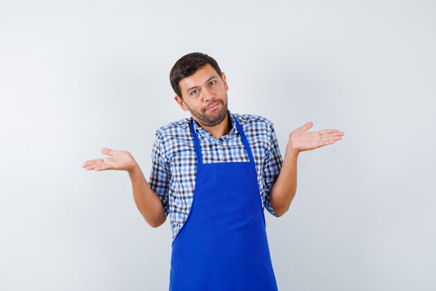 男士穿着蓝色围裙和衬衫的年轻男厨师男士烹饪年轻