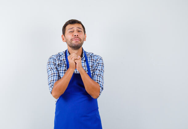 男士穿着蓝色围裙和衬衫的年轻男厨师男士烹饪男士