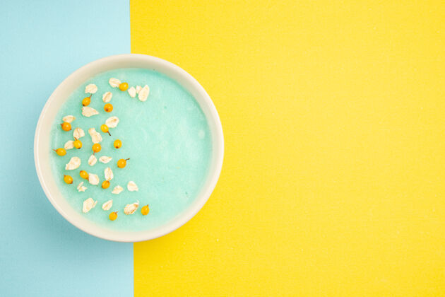 牛奶俯视图蓝色冰甜点内盘上蓝黄色表牛奶色麦片盘子餐具谷类食品