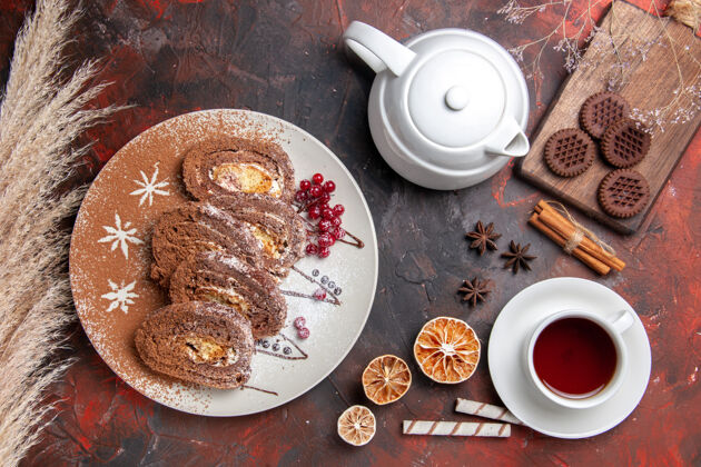 早餐俯瞰美味饼干卷和一杯茶在黑暗的桌子上营养品食物餐