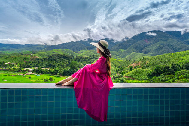风景泰国南部 一位欣赏稻田和绿色森林的女士田野山土地