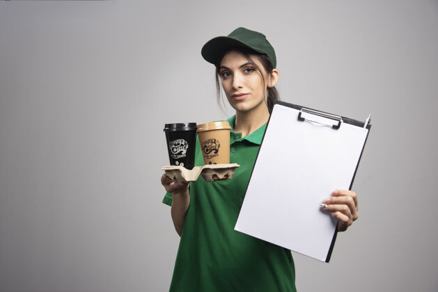 快递绿色的女送货员展示剪贴板咖啡制服剪贴板