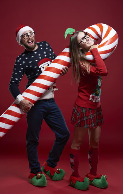 邦德穿着奇怪圣诞服装的年轻夫妇调情糖果手杖精灵