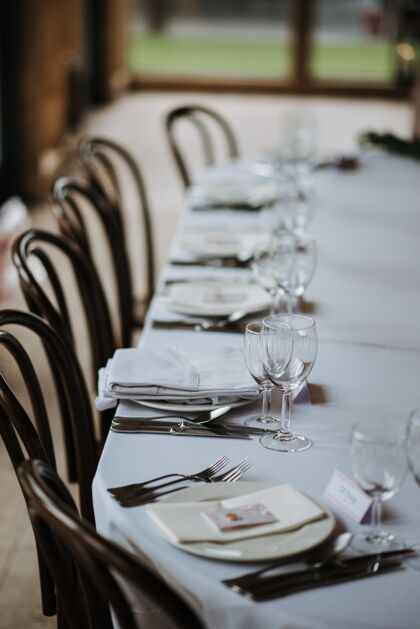 美丽婚礼当天的装饰桌上有盘子 餐巾 酒杯 叉子和刀玻璃婚礼室内