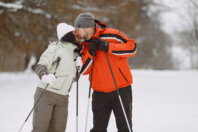 雪冬季公园里快乐的成年夫妇人们穿着运动服在森林里悠闲地跋涉寒冷活动活动