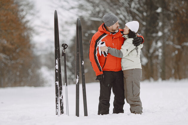 雪冬季公园里快乐的成年夫妇人们穿着运动服在森林里悠闲地跋涉老年人寒冷远足