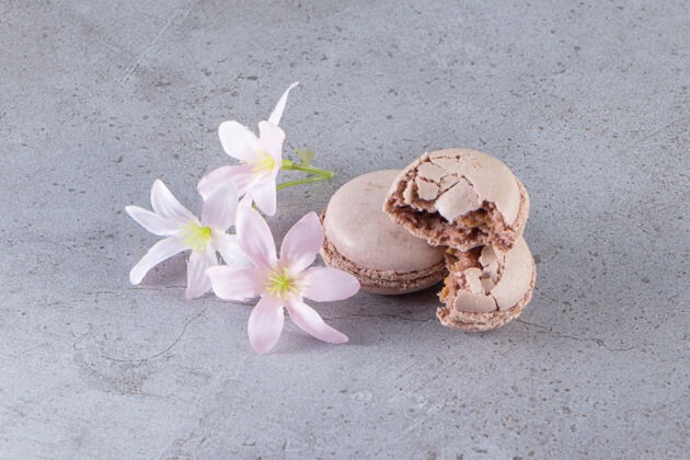 糖果奶油棕色杏仁饼 大理石桌上有粉彩花食品蛋糕鲜花
