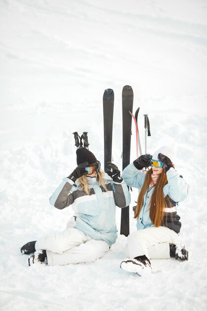 冬天女孩们在雪地里滑雪 享受拍照的乐趣 在山上度过时光休闲运动活跃